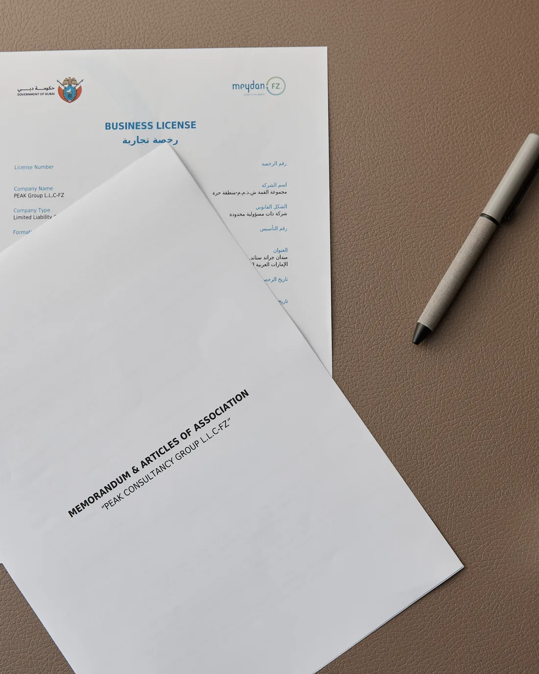 A UAE business licence and memorandum of association on a desk