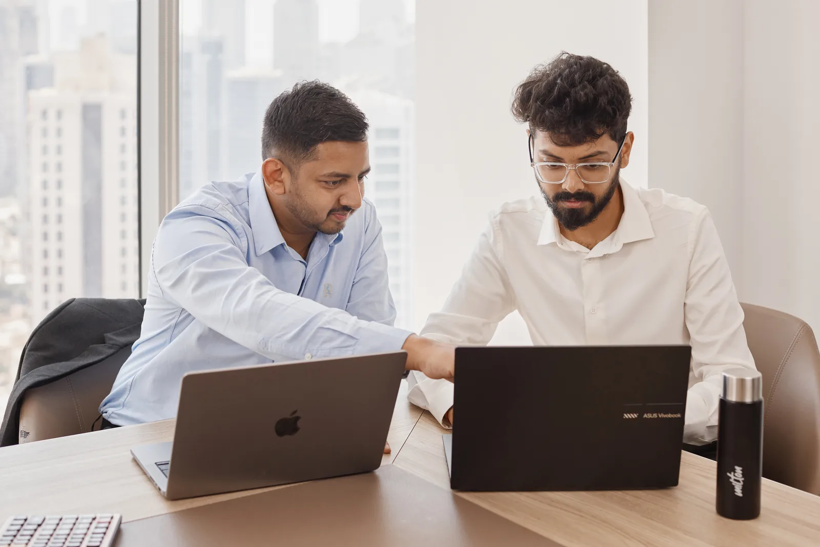 A Peak Consultancy engineer pointing something out on a colleague's screen mid-build